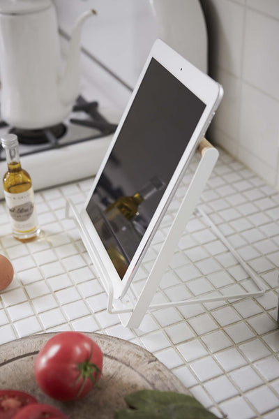 Yamazaki's White book stand holding tablet on tiled kitchen counter