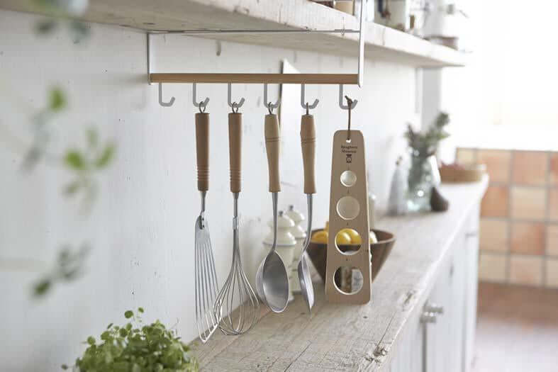 Yamazaki rod holding utensils suspended under a kitchen shelf