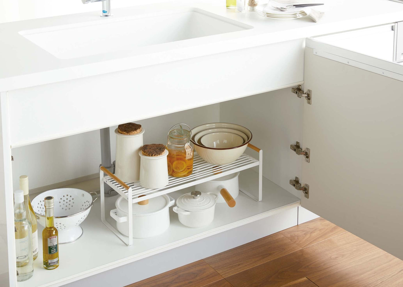 Yamazaki Wired Organizer Rack being used in an under-sink cabinet, stocked with kitchen items